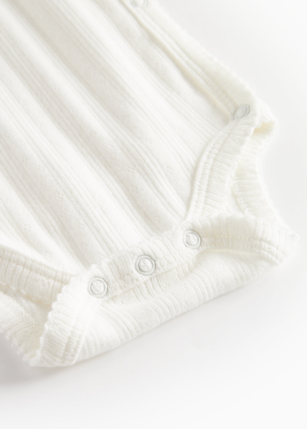 Hvid pointelle slå-om body til baby med lange ærmer