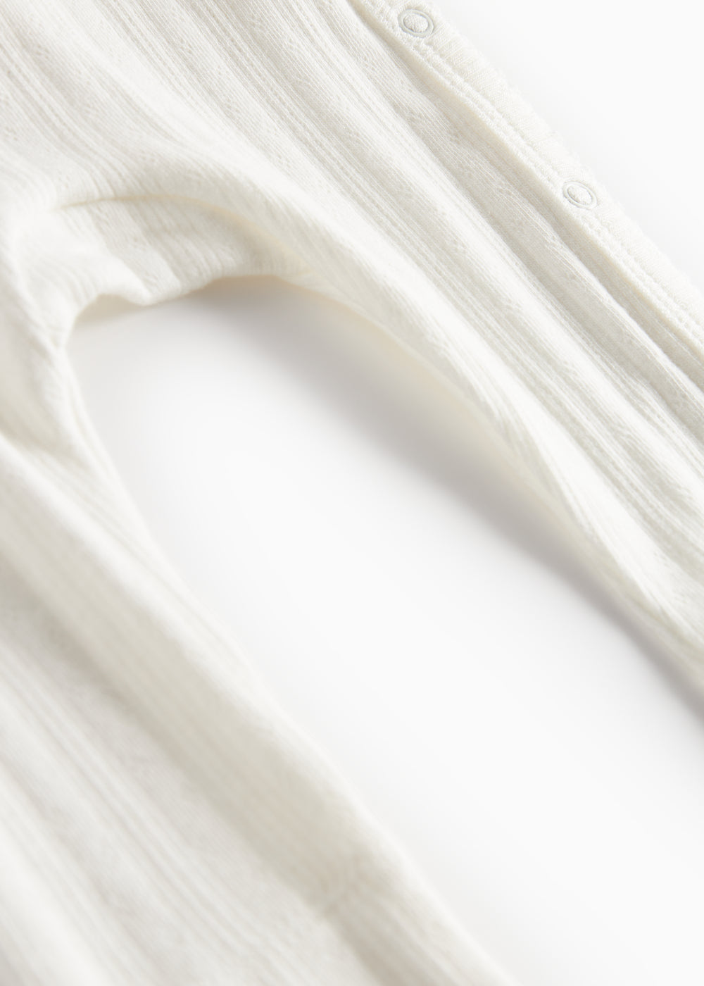 Hvid pointelle heldragt til baby med slå-om lukning og lange ærmer