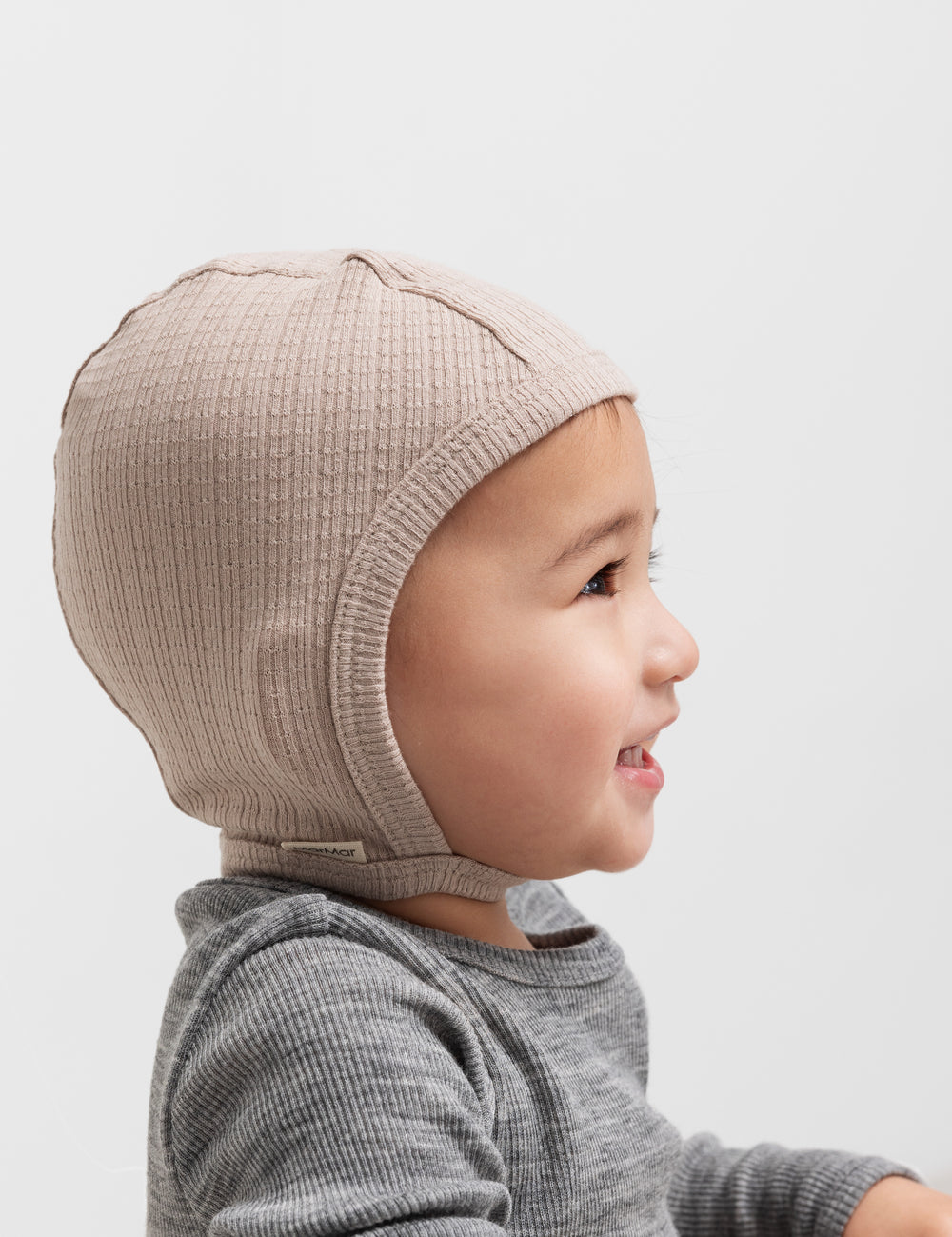 Børn iført beige ribstrikket elefanthue og grå bluse