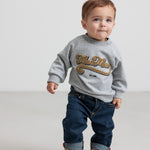 Børn iført grå sweatshirt med guld broderi