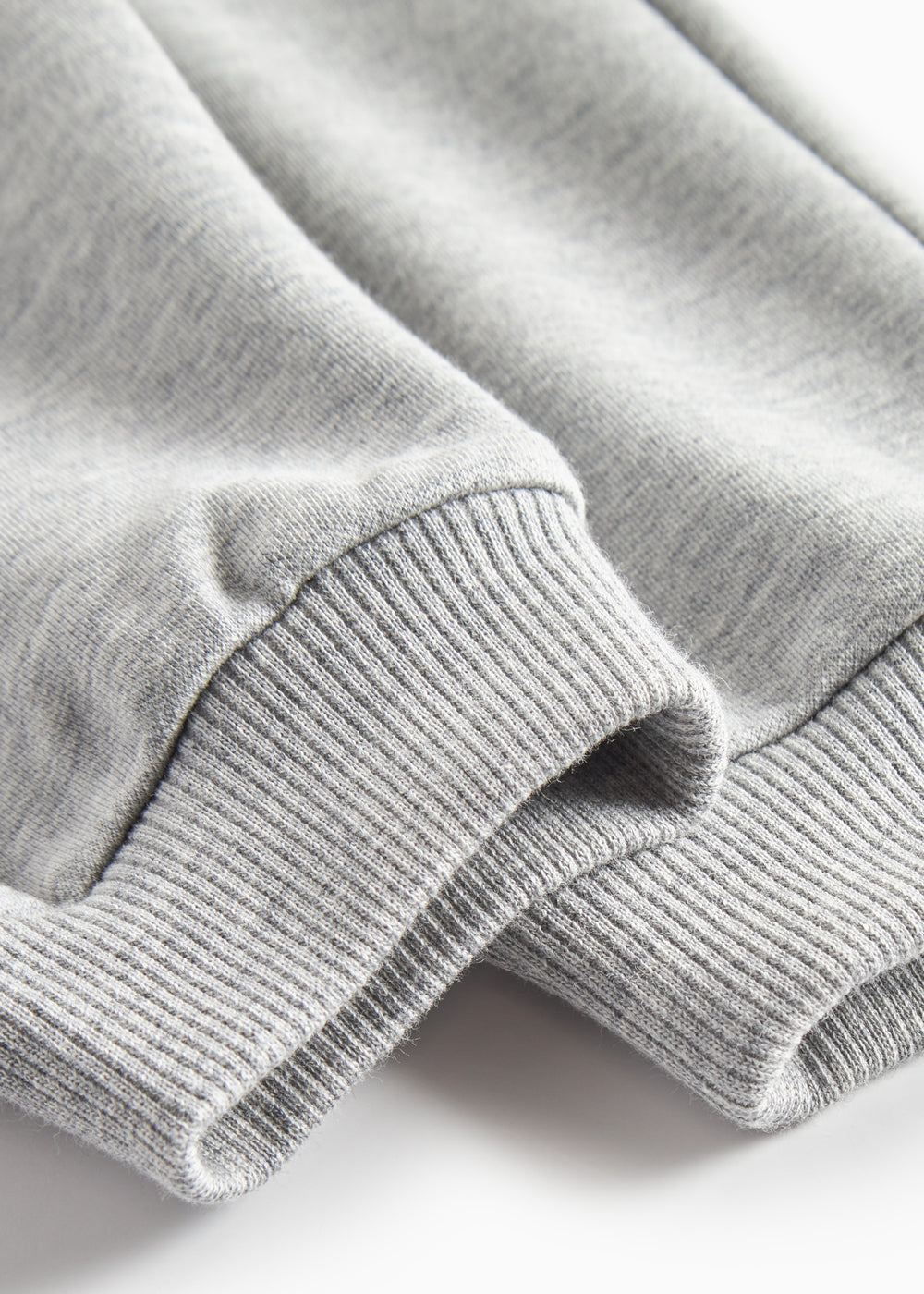 Detalje af ribkant ved ærme på grå sweatshirt