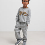 Børn iført grå sweatshirt og grå joggingbukser