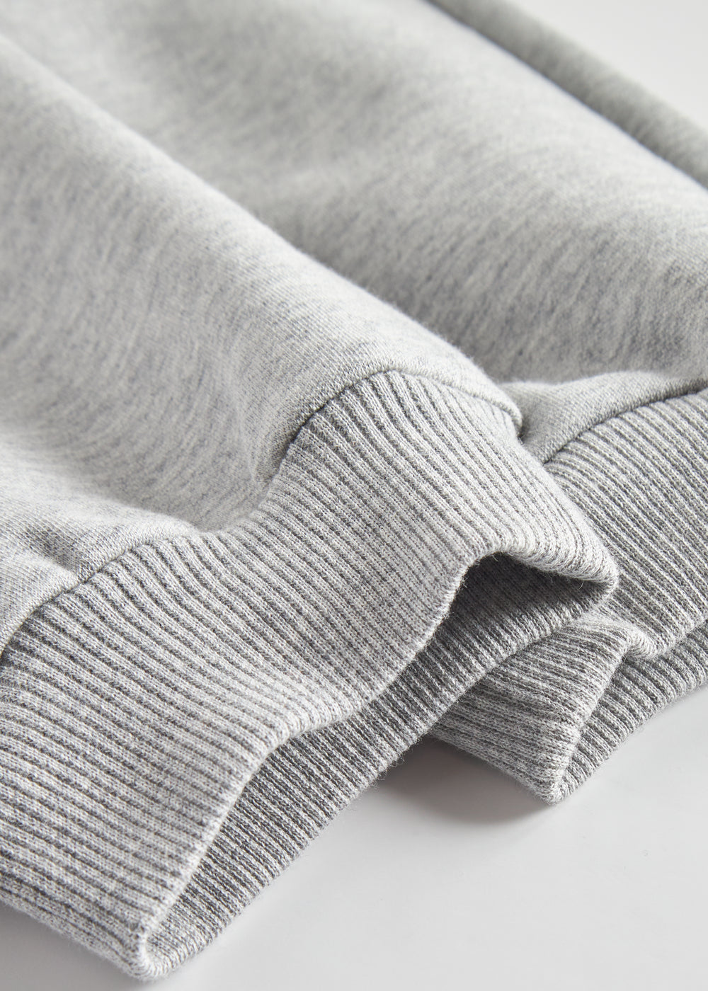 Detalje af ribkant ved ben på grå joggingbukser til børn