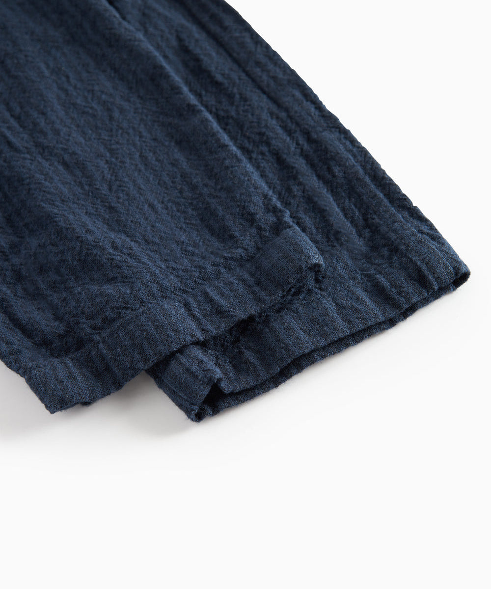 Detaljebillede af stof og søm på mørkeblå bukser