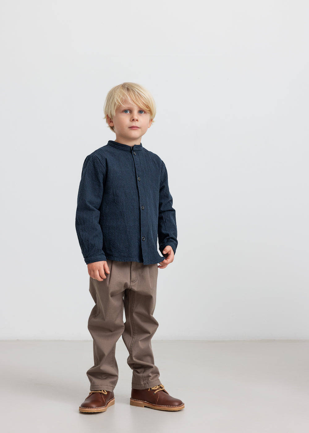 Dreng iført blå jakke og kaki bukser