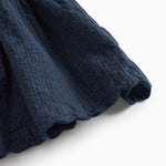 Detaljebillede af skørtets bølgede kant på mørkeblå selekjole