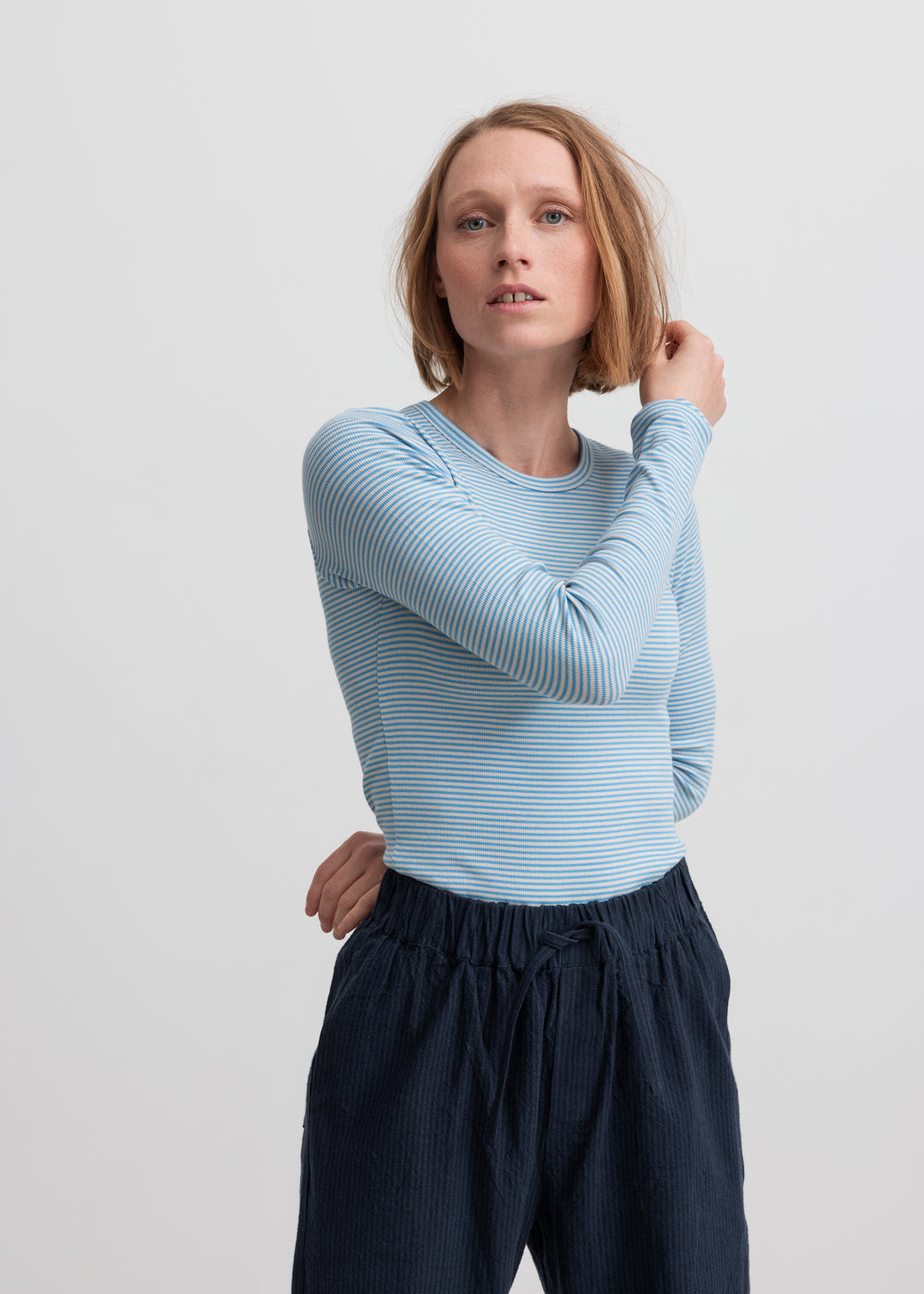 Kvinde iført blå og hvid stribet langærmet T-shirt