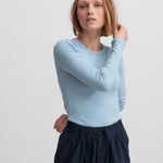 Kvinde iført blå og hvid stribet langærmet T-shirt