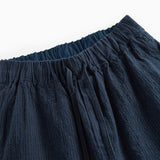 Detaljebillede af mørkeblå damebukser med elastik og let tekstur