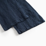 Detaljebillede af mørkeblå damebukser med elastik og let tekstur