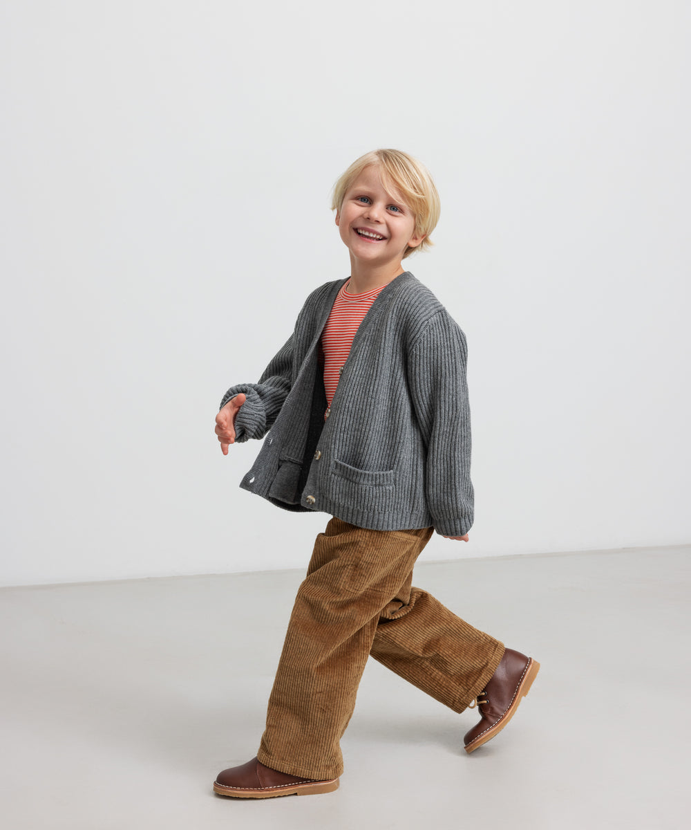 Dreng i brun fløjlsbuks med grå strikket cardigan