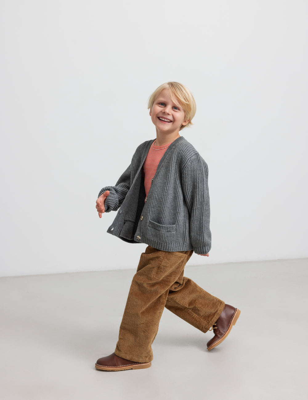 Dreng i brun fløjlsbuks med grå strikket cardigan