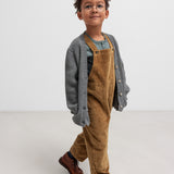 Dreng iført grøn ribstrikket bluse og brun overall