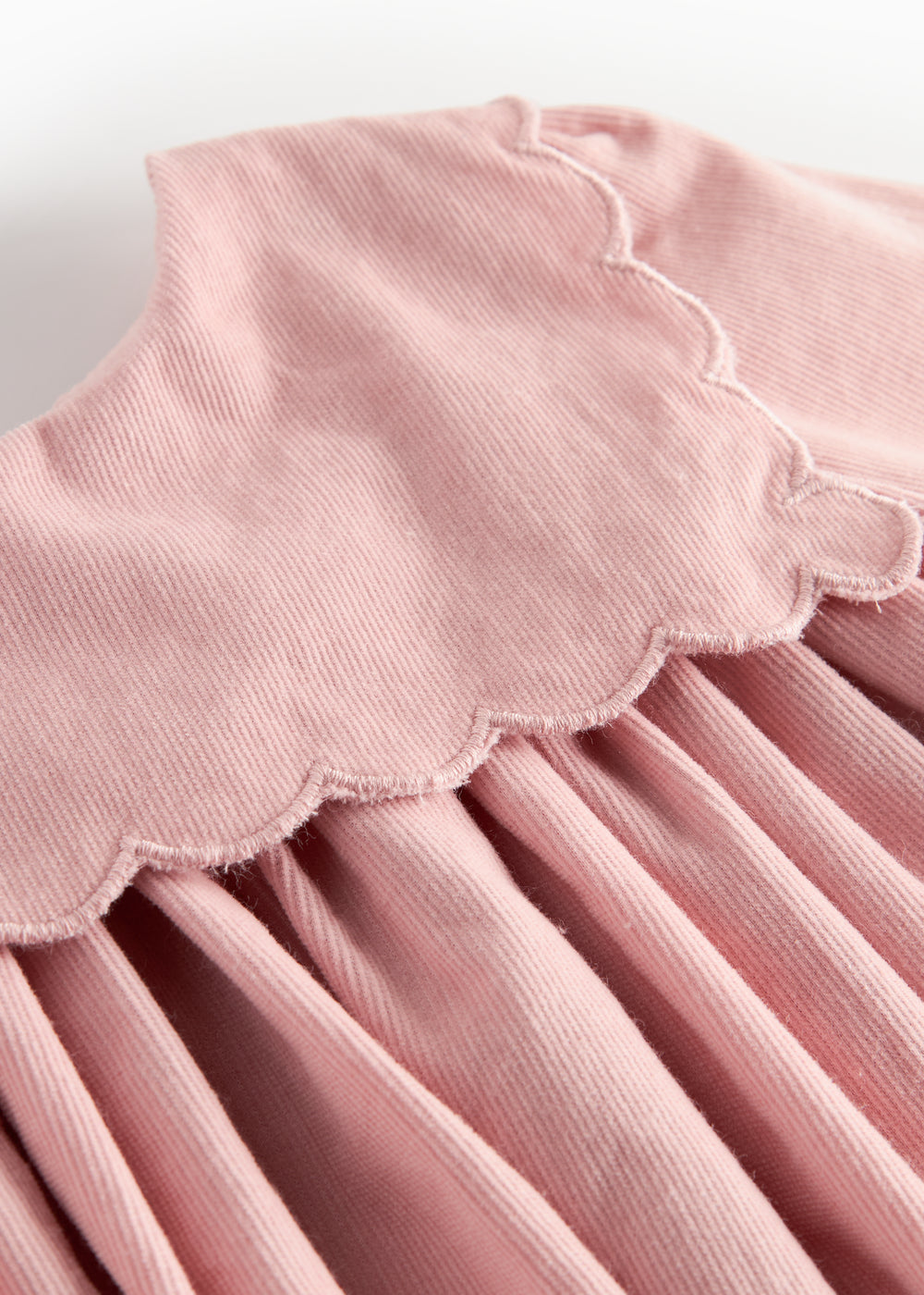 Lyserød babyfløjlskjole med lange ærmer, bølgekant og lommer til børn