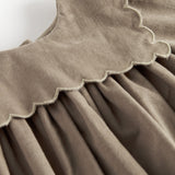 Beige babyfløjlskjole med lange ærmer, bølgekant og lommer til børn