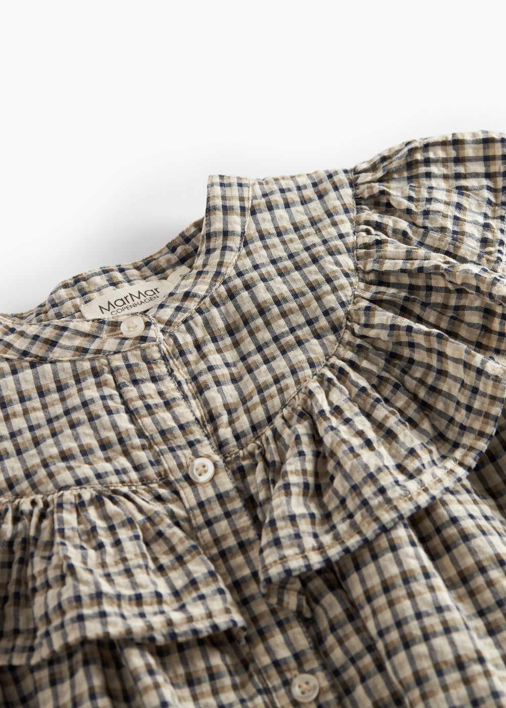 Detalje af flæser på brun ternet strikkjole