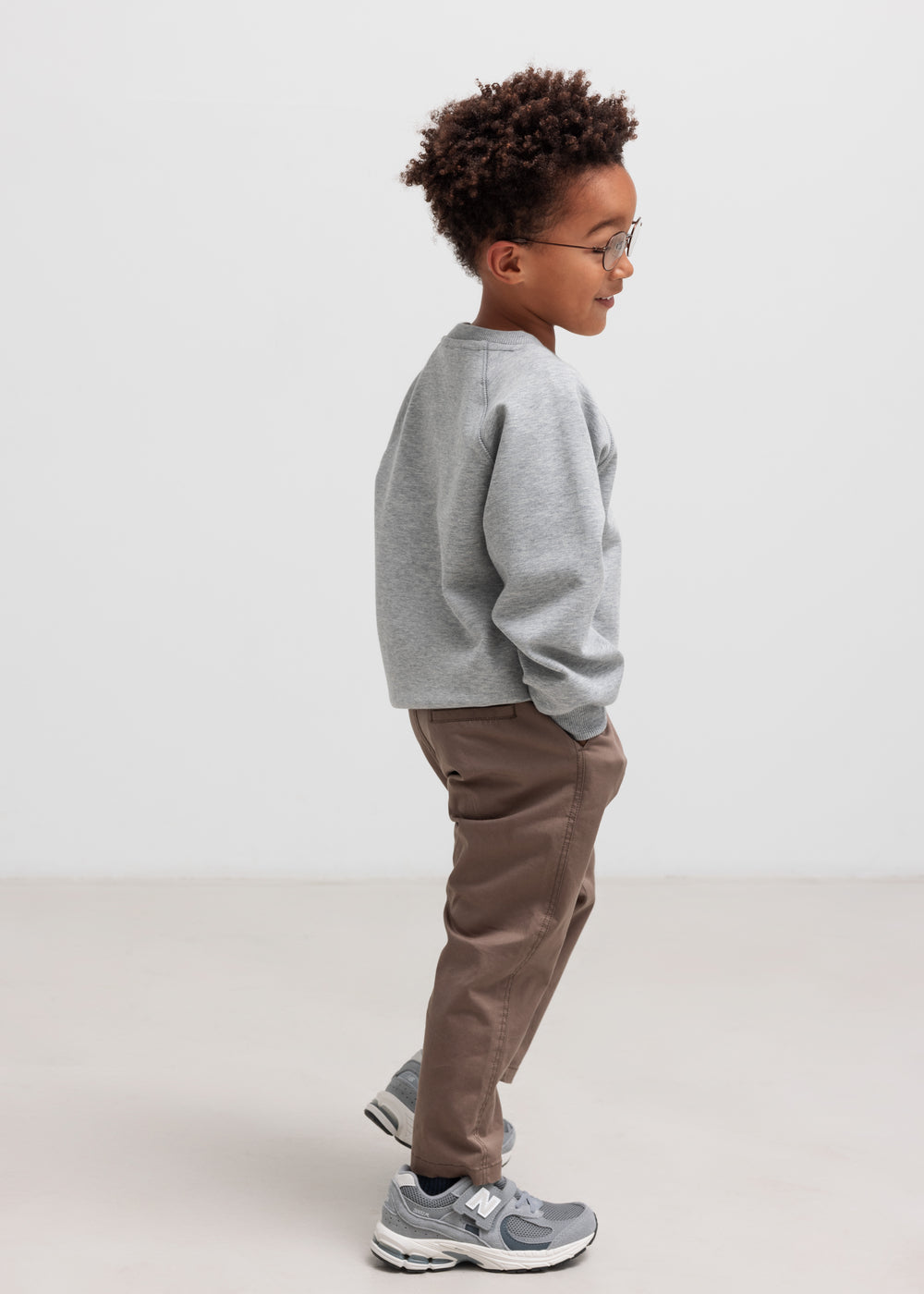 Dreng iført grå trøje og kaki bukser