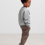 Dreng iført grå trøje og kaki bukser