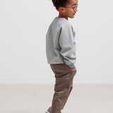 Dreng iført grå trøje og kaki bukser