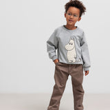Dreng iført grå Moomin trøje og kaki bukser a