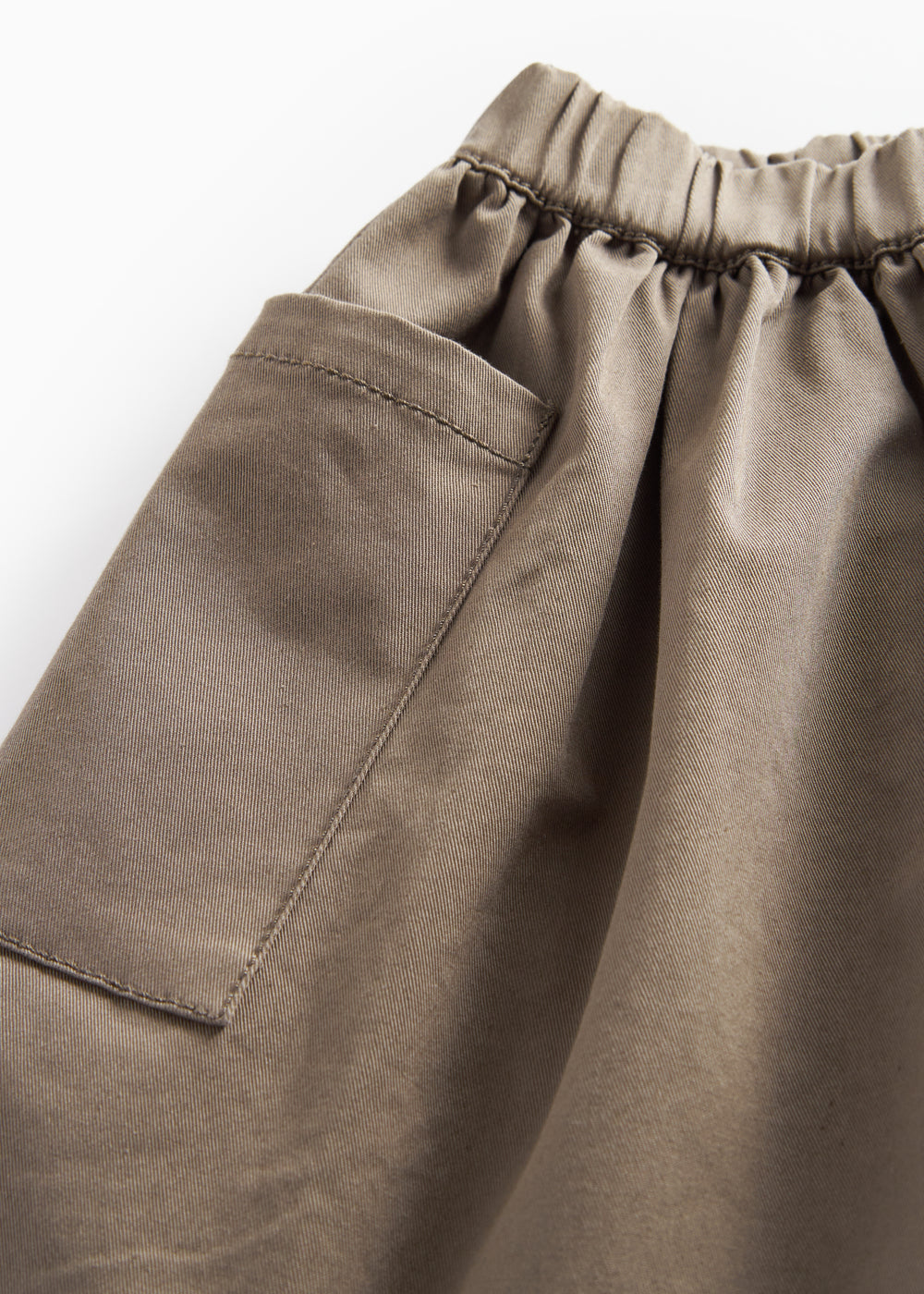 Detaljebillede af elastisk talje på kaki nederdel