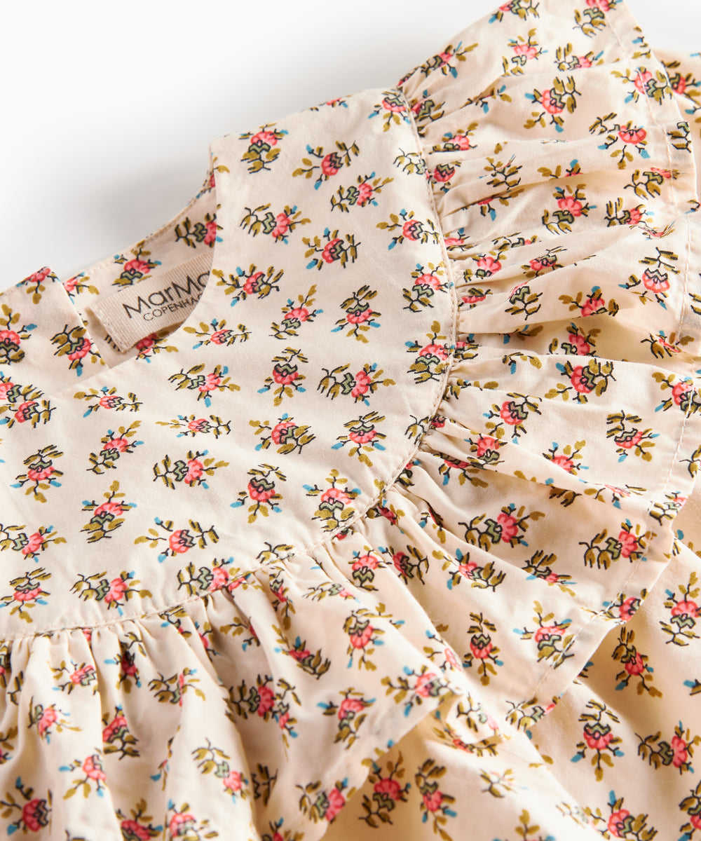 Nærbillede af kjole med blomstermønster og flæser