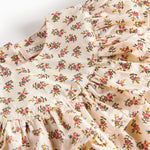 Nærbillede af kjole med blomstermønster og flæser