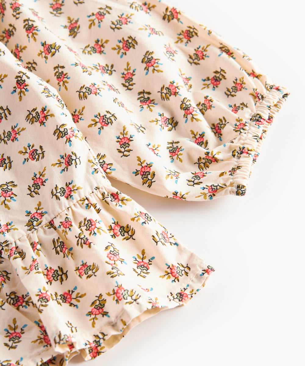 Nærbillede af kjole med blomstermønster og flæser