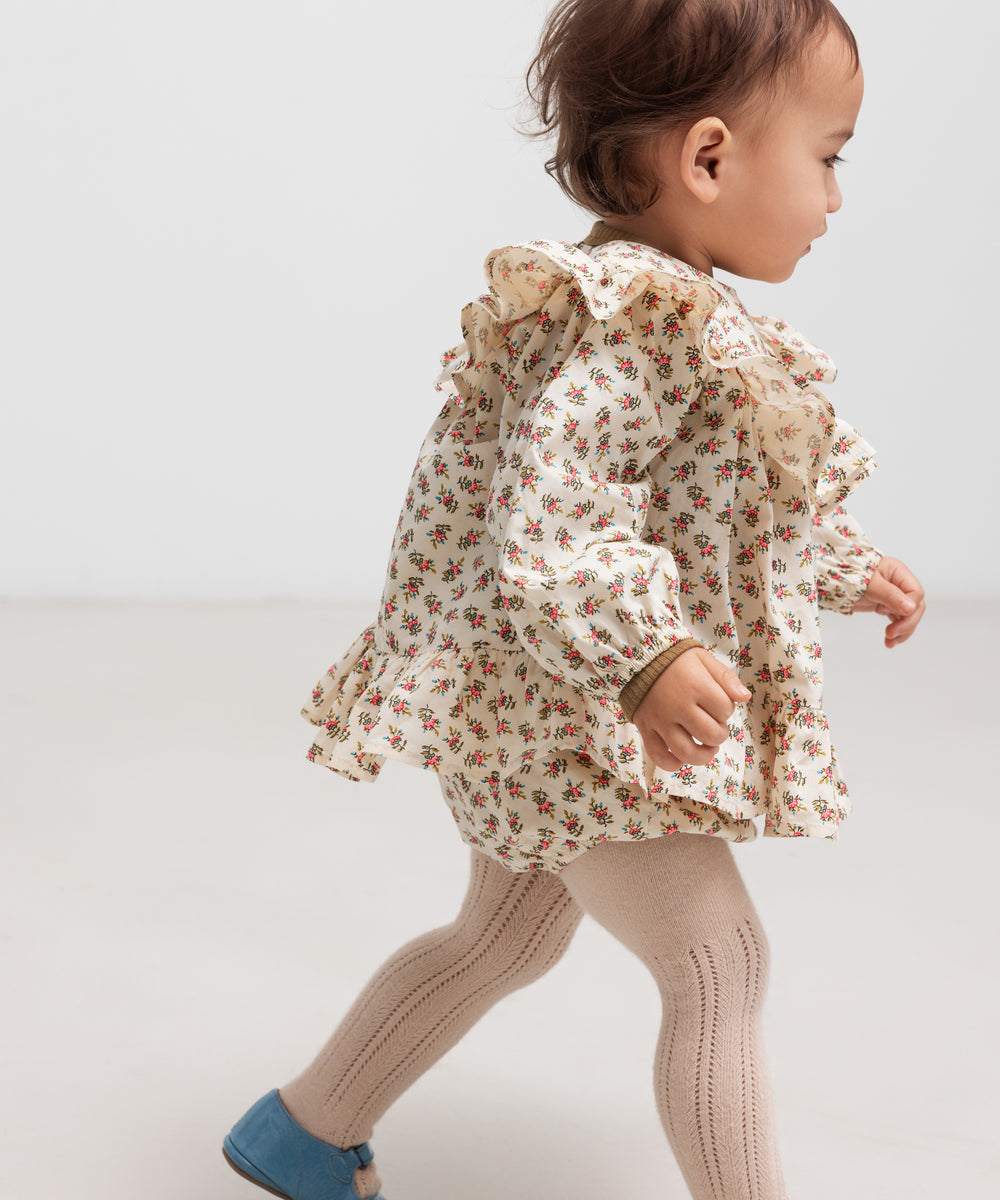 Baby iført bloomers med blomsterprint og elastisk talje