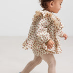 Baby iført bloomers med blomsterprint og elastisk talje