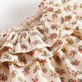 Detaljebillede af kjole med blomstermønster og flæsedetaljer