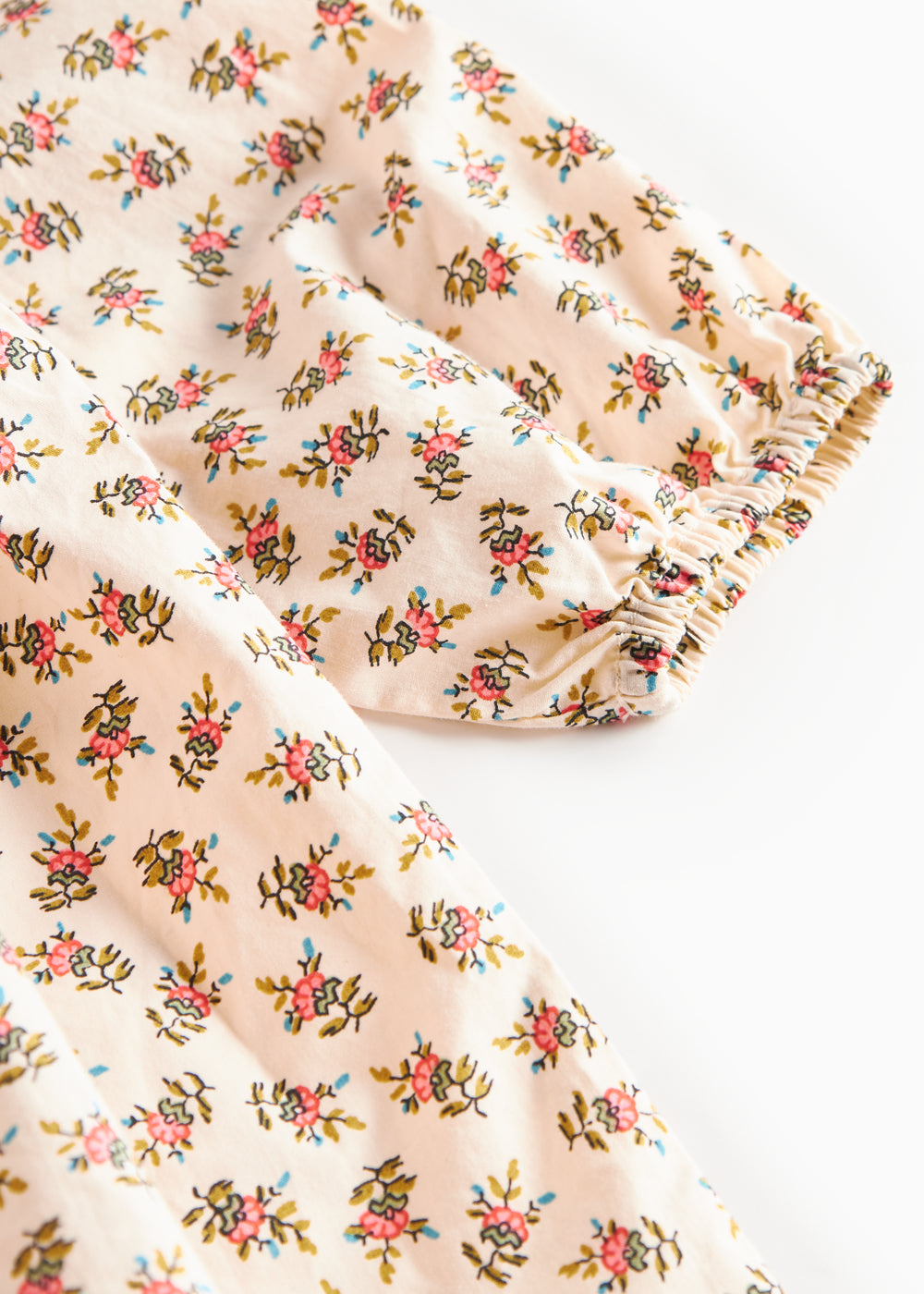 Nærbillede af kjoleærme med blomstermønster og elastik