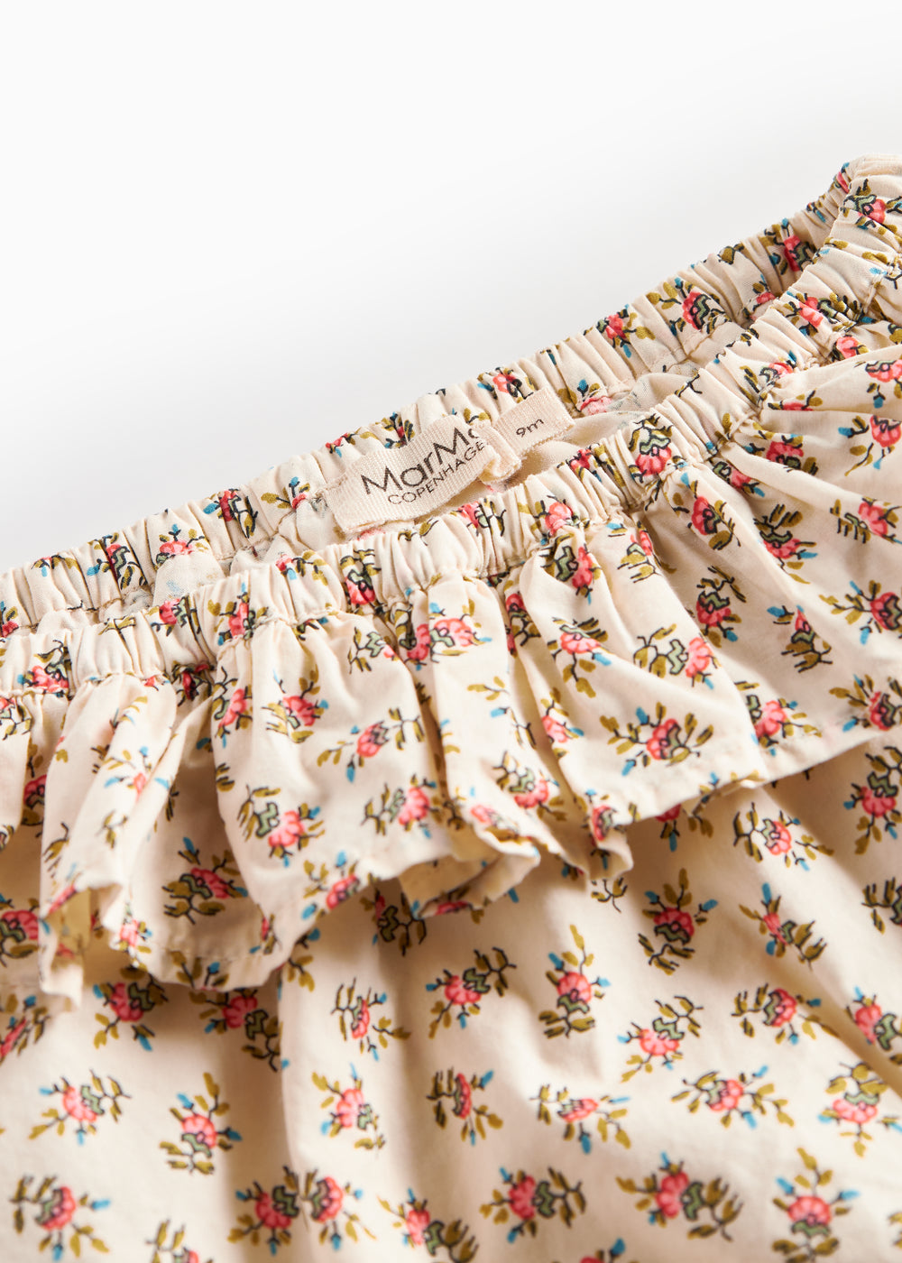 Detaljebillede af bloomers med blomstermønster og flæser