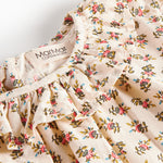 Detaljebillede af bluse med blomstermønster og flæsedetalje