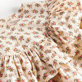 Detaljebillede af flæseærme og blomsterprint på kjole