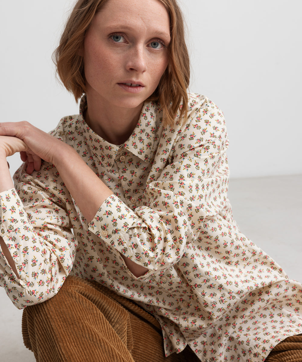 Kvinde iført brune fløjlsbukser og mønstret bluse