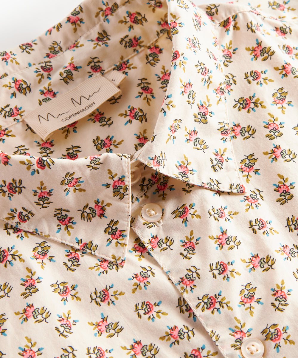 Detaljebillede af blomstret skjorte med knapper og blomsterprint