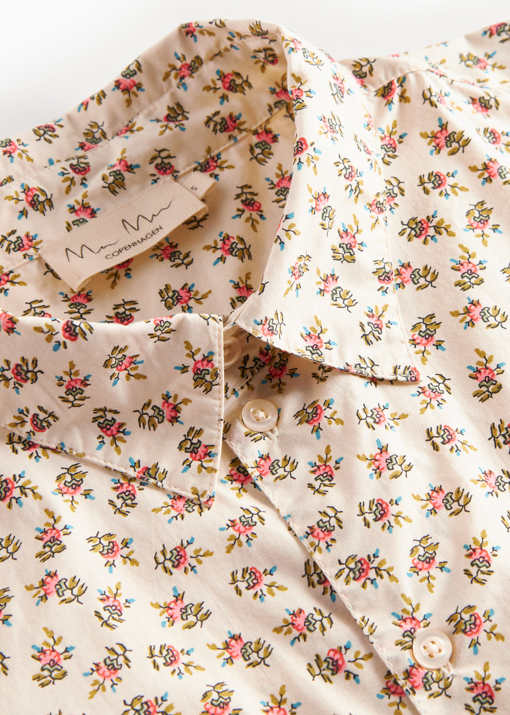 Detaljebillede af blomstret skjorte med knapper og blomsterprint
