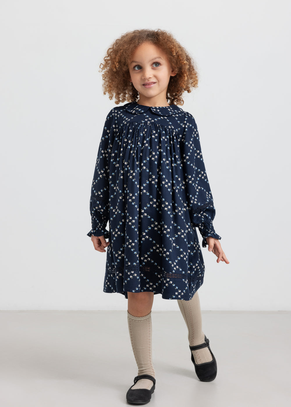 Pige iført mørkeblå blomstermønstret kjole