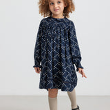 Pige iført mørkeblå blomstermønstret kjole