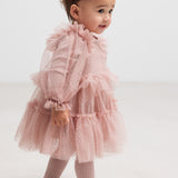 Lille børn i lyserød tylkjole med flæser og lange ærmer