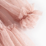 Nærbillede af lyserød tylkjole med elastiske manchetter og flæser