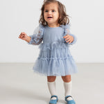 Lille børn i blå tylkjole med flæser og lange ærmer