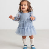 Lille børn i blå tylkjole med flæser og lange ærmer