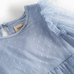 Detaljebillede af blå tylkjole med prikmønster og flæser på skuldrene