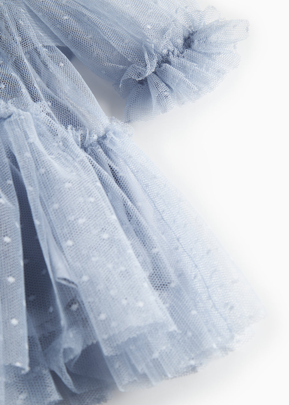 Nærbillede af blå tylkjole med let stof og flæsedetaljer