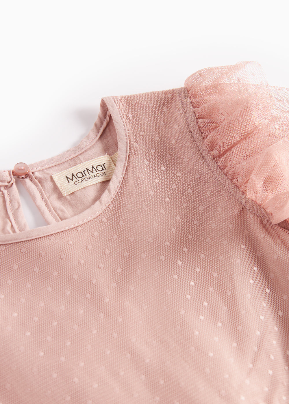 Nærbillede af rosa tylkjole med fint prikmønster og flæsekant på skuldrene