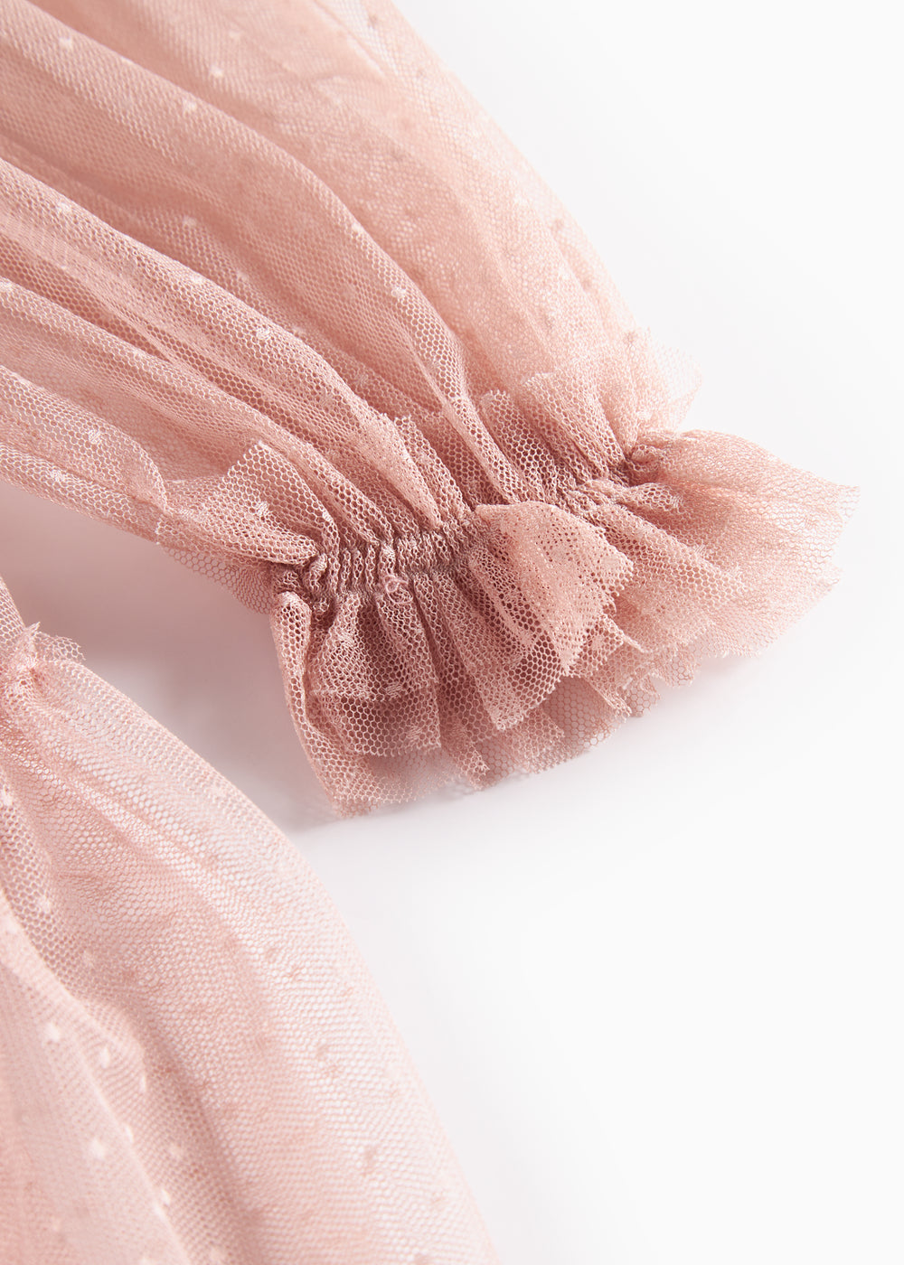 Detaljebillede af rosa tylkjole med elastisk manchet og volanger