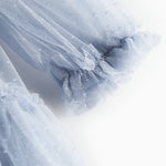 Nærbillede af blå tylkjole med volanger på ærmerne