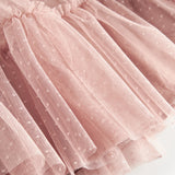 Nærbillede af lagdelt lyserød tylnederdel med fint prikmønster